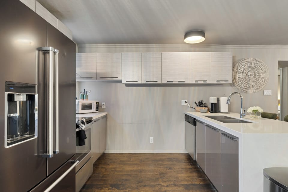 Spacious kitchen with sleek modern appliances and granite countertops. 
