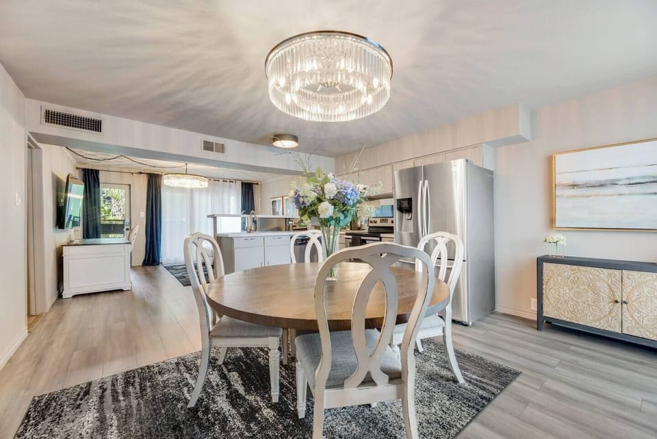 Open dining area with seating for four, featuring a beautiful chandelier..