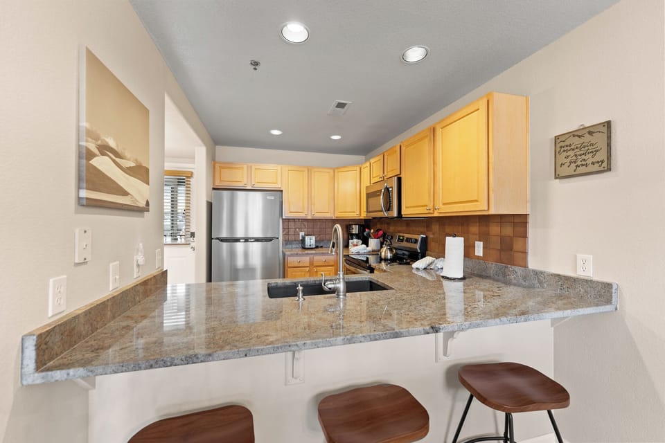 Your spacious kitchen features granite countertops, stainless steel appliances, and a breakfast bar where you can start each morning.