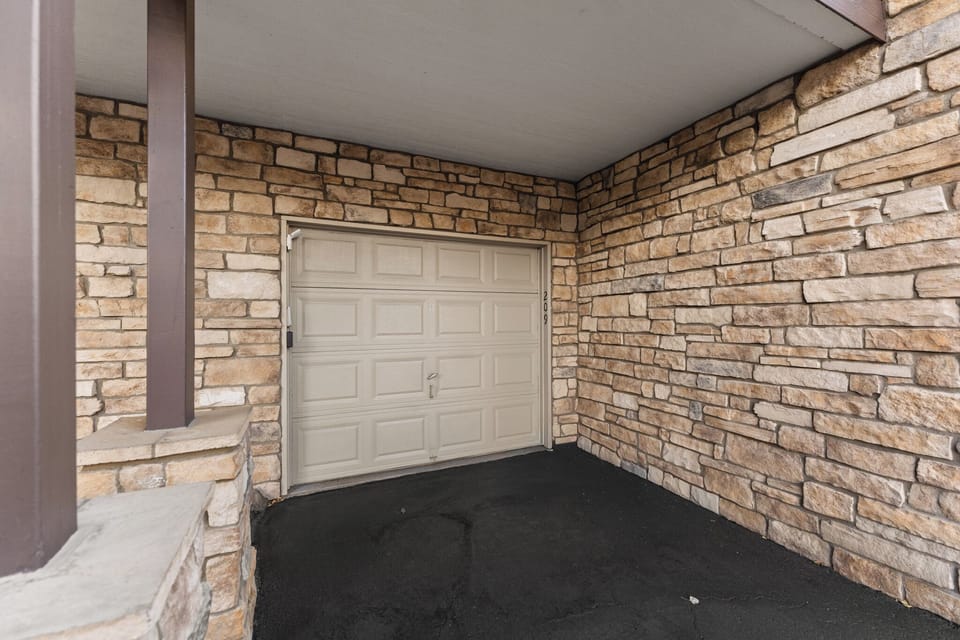 Secure covered garage provides protected parking for your vehicle with convenient stone-accented architecture.