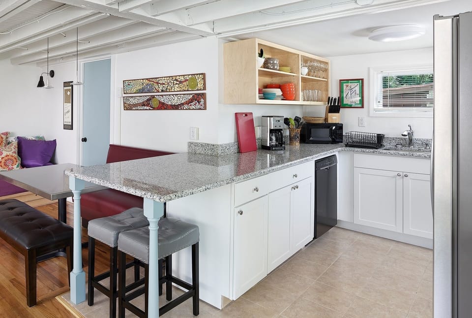Fully equipped kitchen has a breakfast bar, dining booth, and updated appliances.