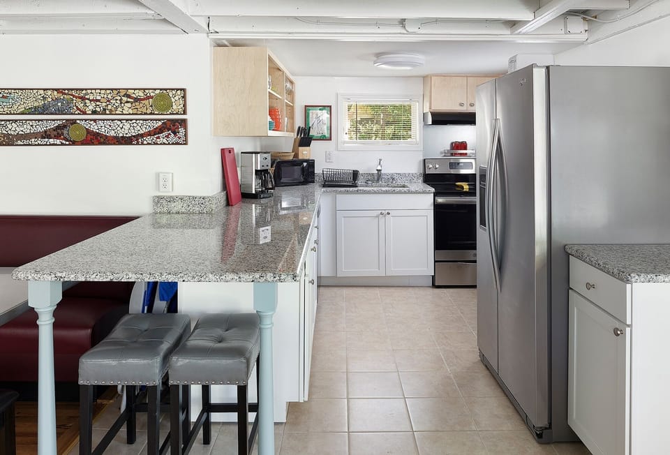 Fully equipped kitchen has a breakfast bar, dining booth, and updated appliances.