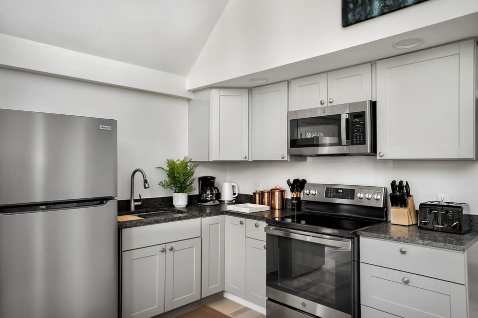 Fully-stocked kitchen with fridge, stove/oven, and microwave