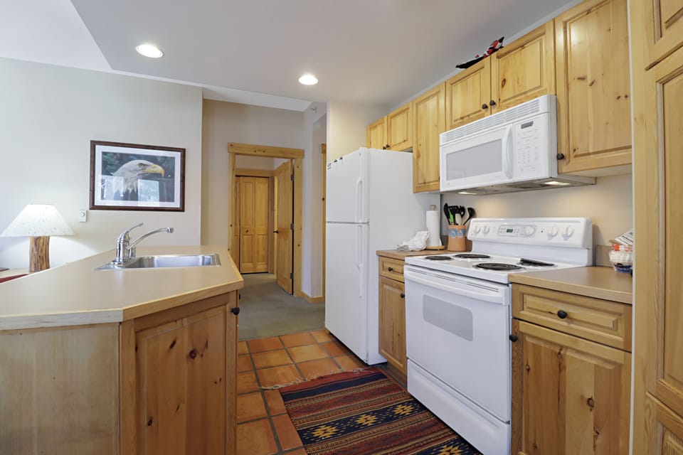 Your fully equipped kitchen features warm wood cabinets, full appliances, and all the essentials for preparing home-cooked meals during your stay.