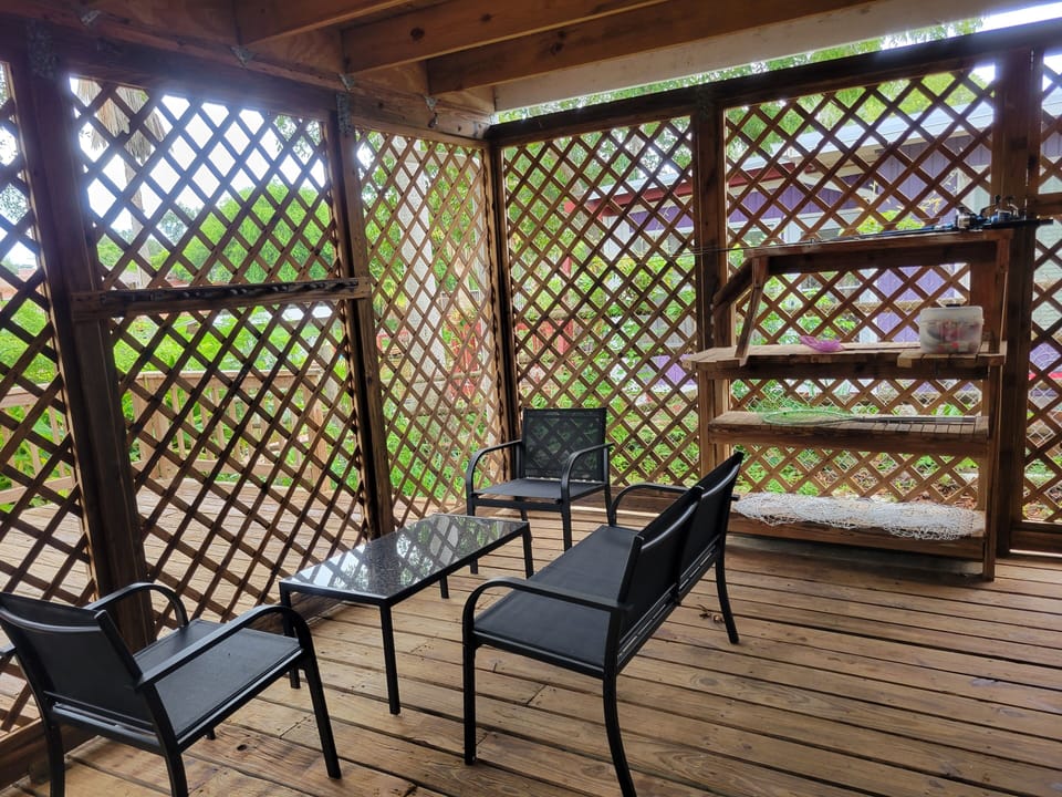 Covered Deck with Chairs and Table, Fishing Rods, Crab Nets, and Kayak