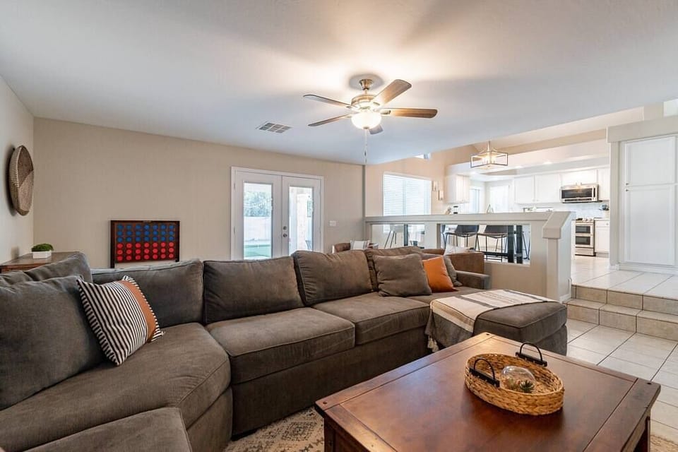 The second living room is cozy - with a soft sectional couch and double doors that exit to the backyard.  Catch the news or a formula one race from the breakfast bar!