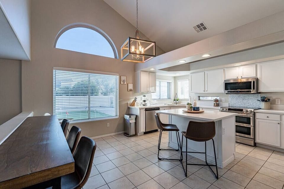The kitchen overlooks the backyard, and features a breakfast bar (left) facing the living room television