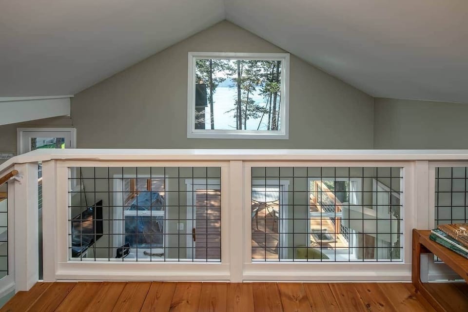 Loft bedroom with king bed, smart tv and a peekaboo window with water views.