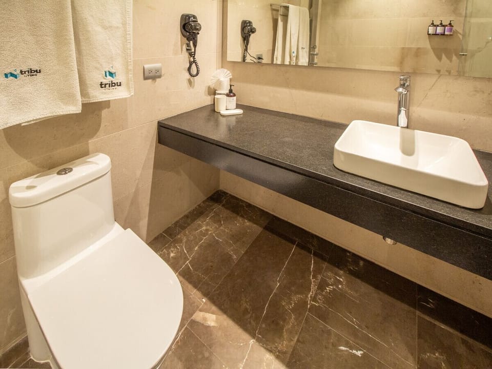 Baño moderno con un amplio tocador y excelente iluminación para que te prepares cómodamente cada mañana.