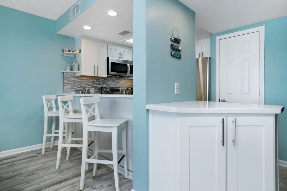 Your bright, coastal-inspired kitchen awaits with modern appliances and a breakfast bar perfect for morning coffee.