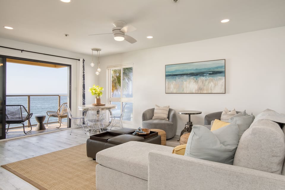 The living room features a sleeper sofa, TV, and dining table.