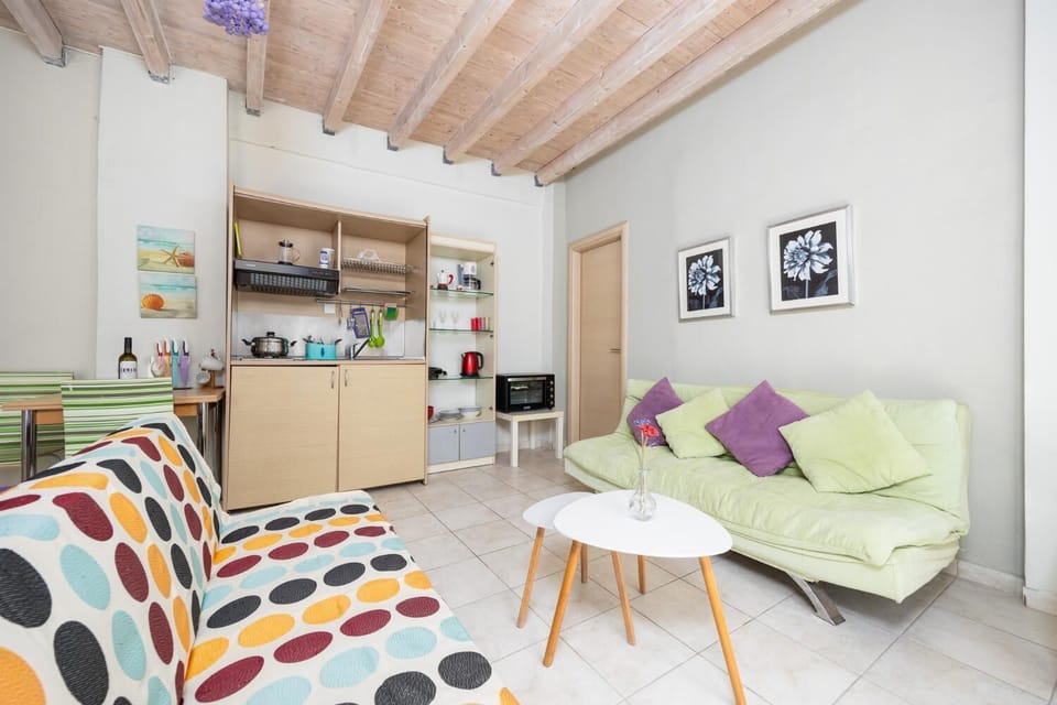 Open-plan living room with sofas, dining area, kitchen, A/C, WiFi internet, and satellite TV