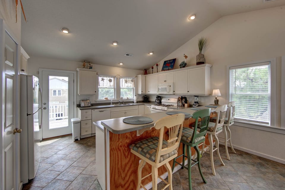 Kitchen Bar - This open concept floor plan  offers a large dining table and bright kitchen.
