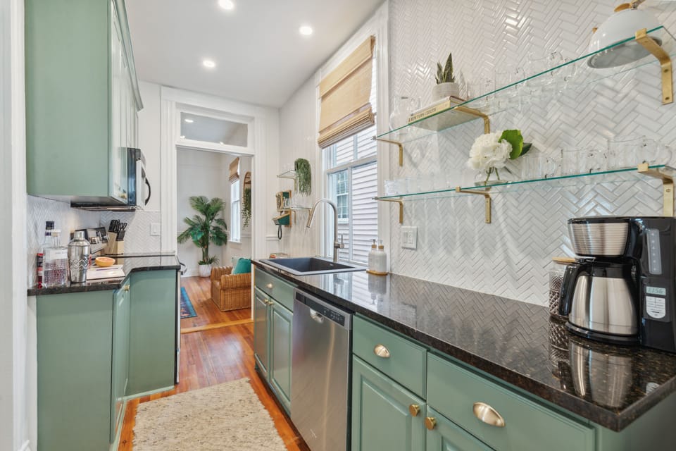 Beautifully refinished kitchen with granite countertops and green cabinets