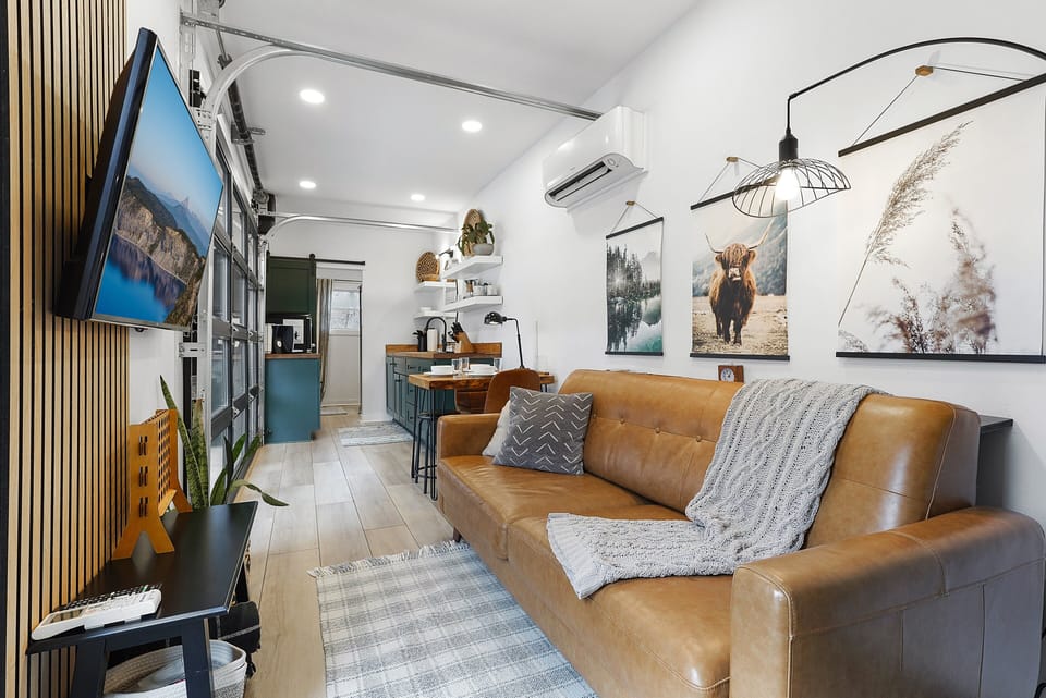 Step through the front door and into your living room space with a comfy leather sofa and smart TV.