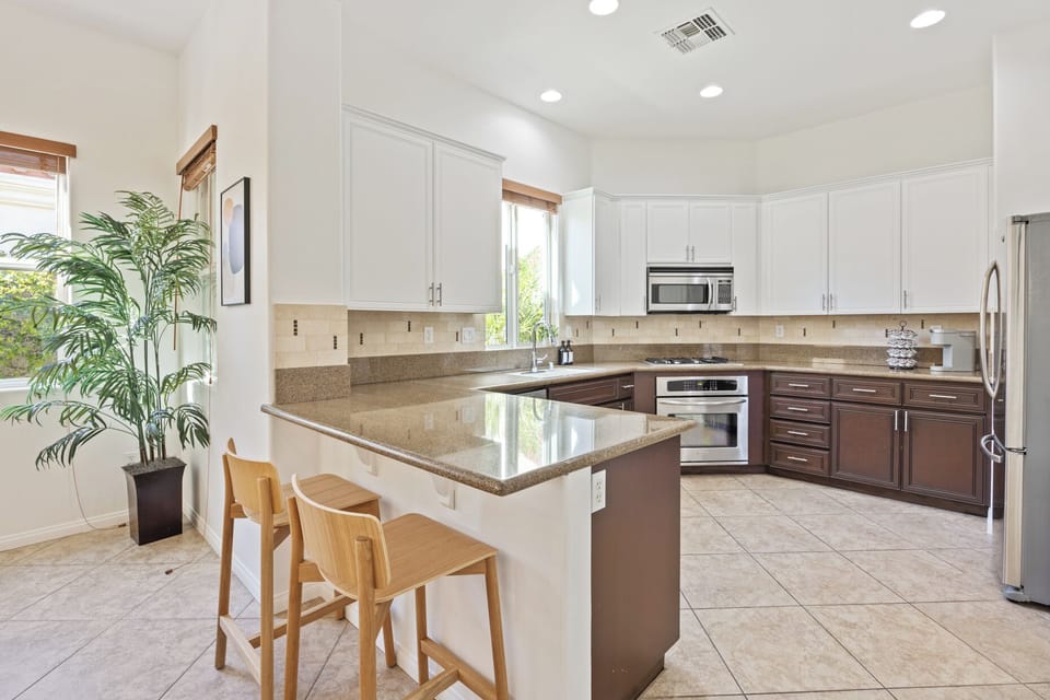 Bright kitchen with breakfast bar seating connects perfectly to dining and living areas.