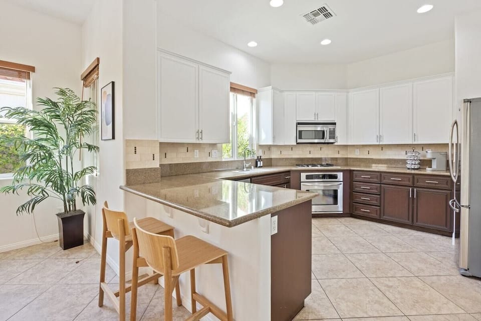 Bright kitchen with breakfast bar seating connects perfectly to dining and living areas.