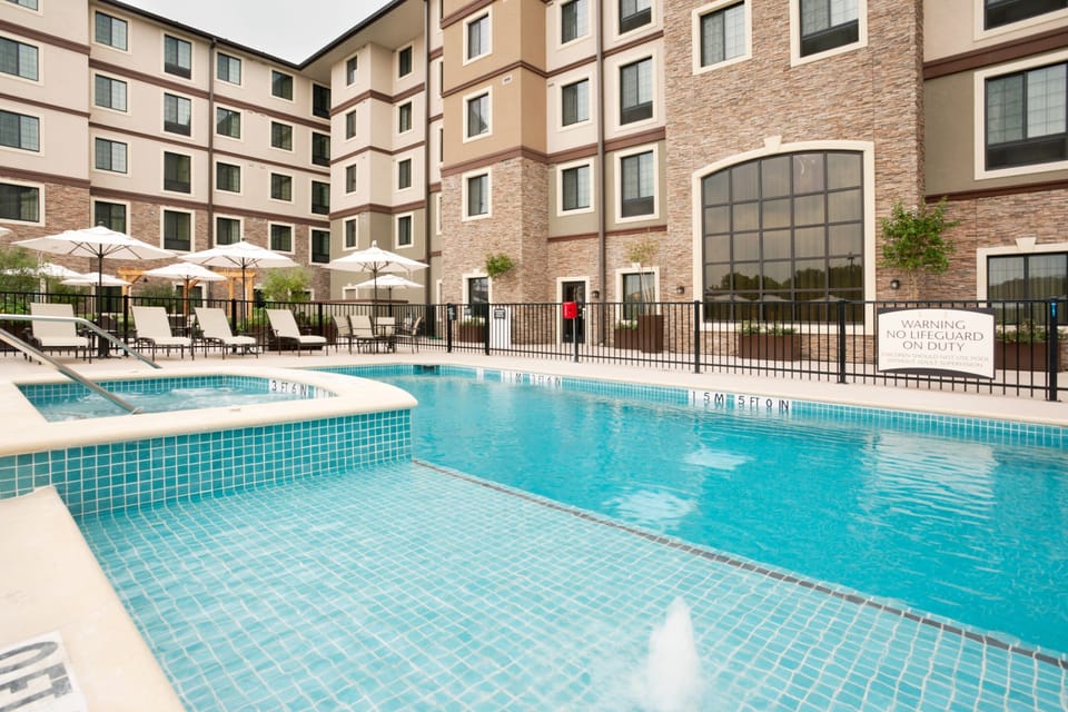 Outdoor pool with lounge chairs and umbrellas.