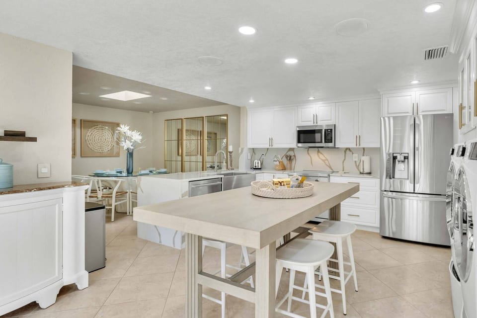 The kitchen is a spacious area with a large center island. The appliances are seamlessly integrated, giving it a sleek modern look.