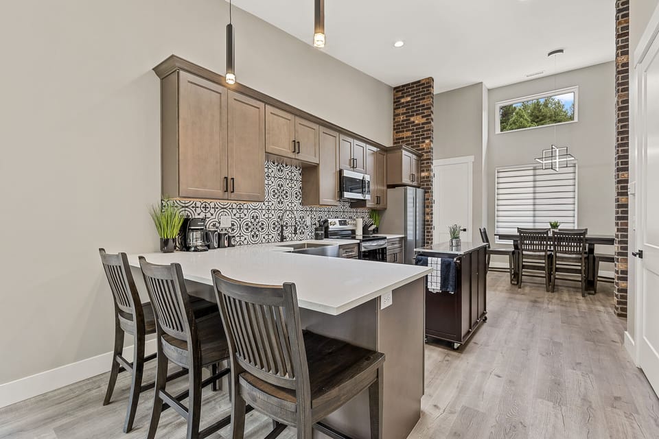 Spacious vaulted ceilings with transom windows let the light pour in Top level kitchen and dining table