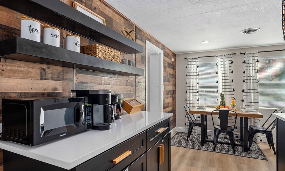 Make snacks or meals with handy countertop appliances by a wood-paneled wall.