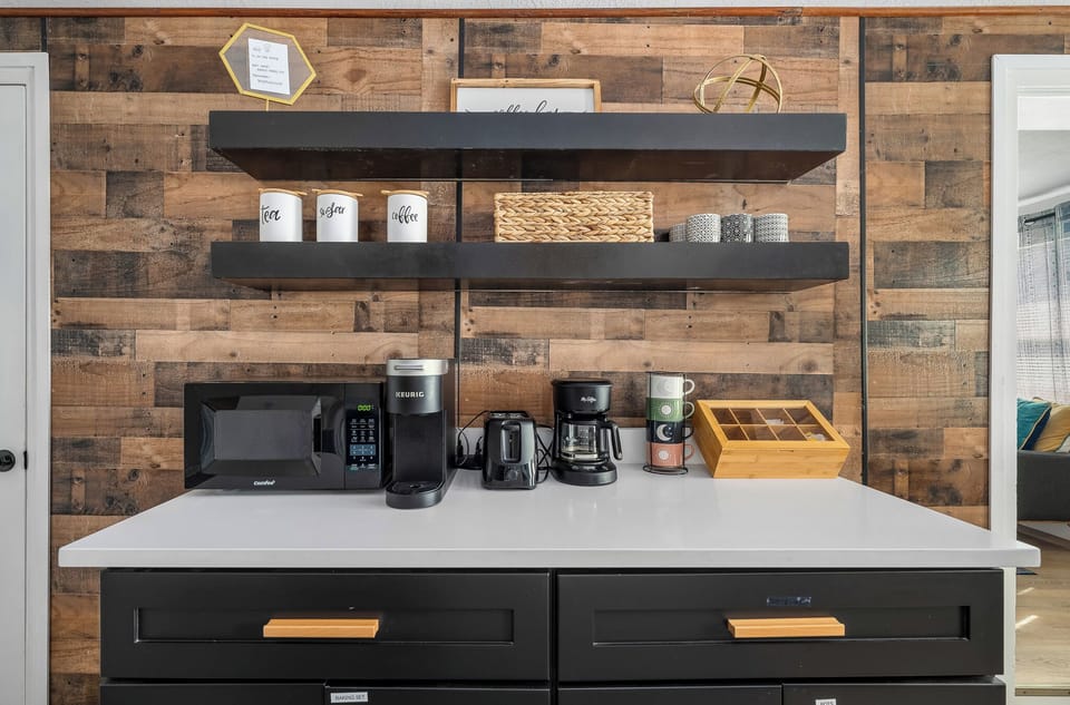 Enjoy coffee or tea anytime at the beverage station with microwave and shelving.