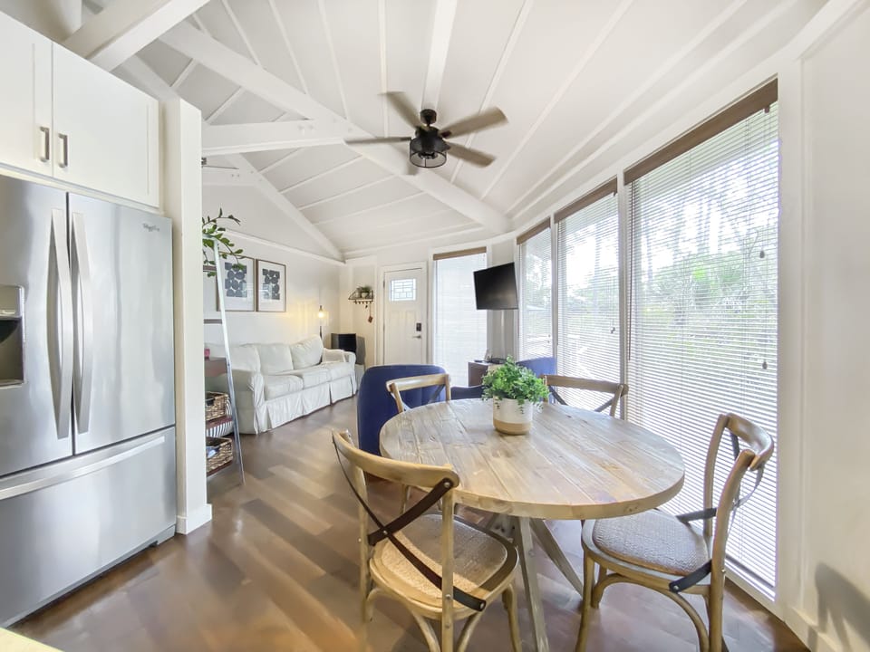 Open dining, kitchen and living concept with floor to ceiling windows.