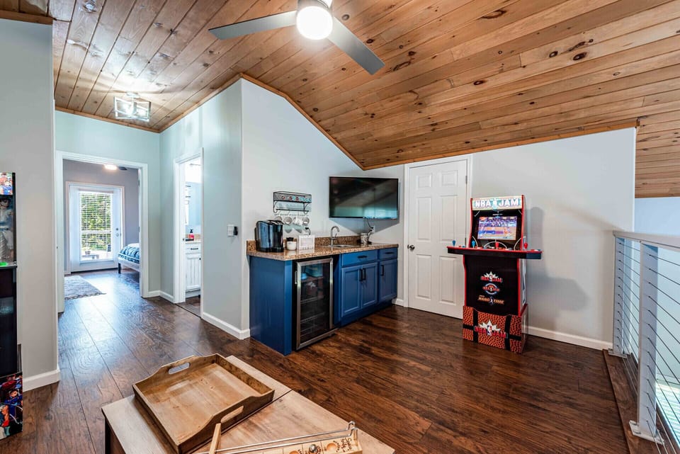 Loft area with 2 arcade games, small couch, & board games. 