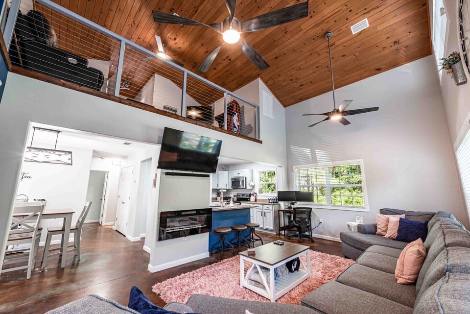 Living room with electric fireplace, smart TV, sound bar, large sofa. 