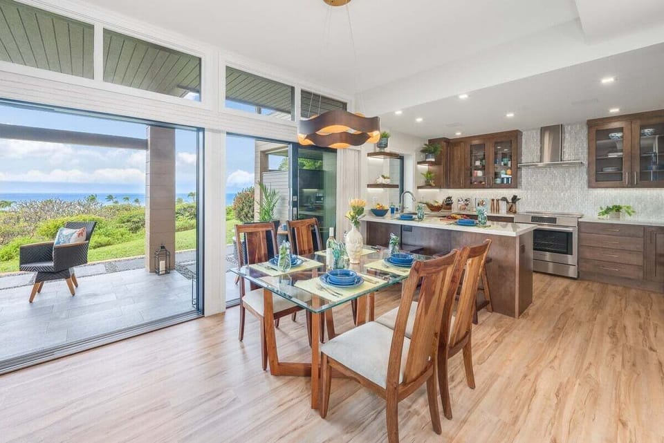Dining table for four overlooking greenery, positioned near the lanai for fresh air and easy indoor‑outdoor dining.