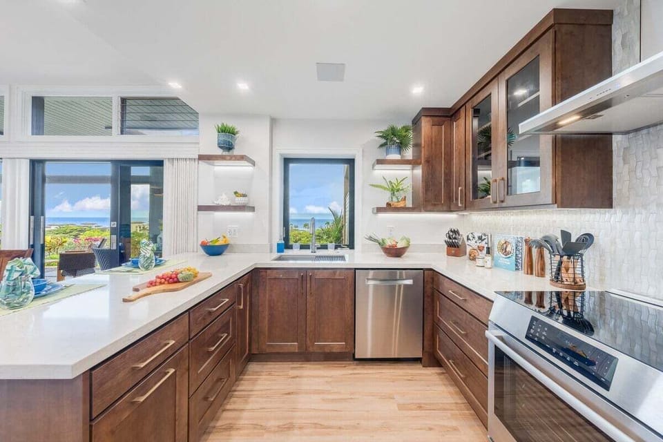 Fully remodeled kitchen with new Bosch appliances, warm wood cabinetry, bar seating, and modern finishes ideal for home‑cooked meals.