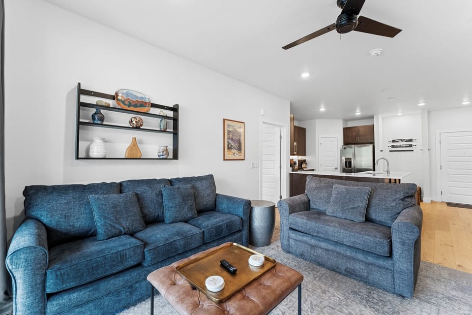 Unwind in your stylish living space with plush blue sofas and modern touches, perfect for relaxing after exploring.