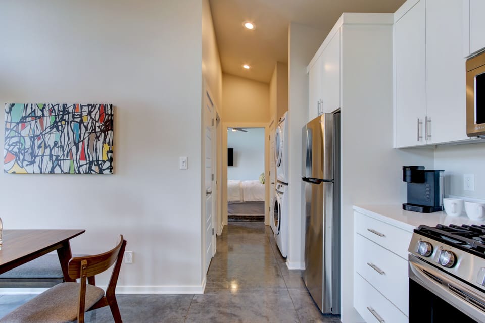 Hallway to second bedroom and bathroom with stacking washer & dryer.
