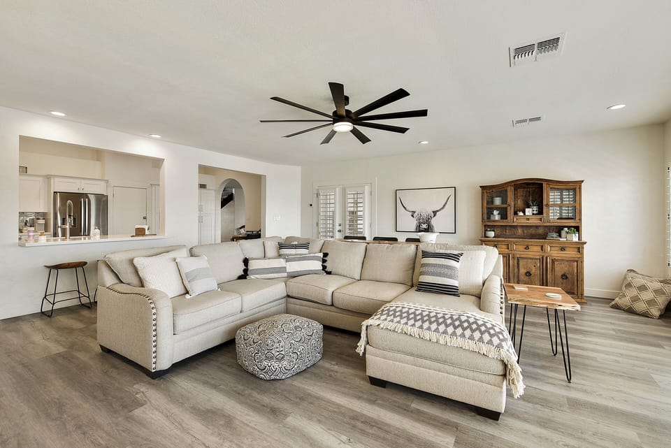 There is a sofa table behind the couch that offers more seating.