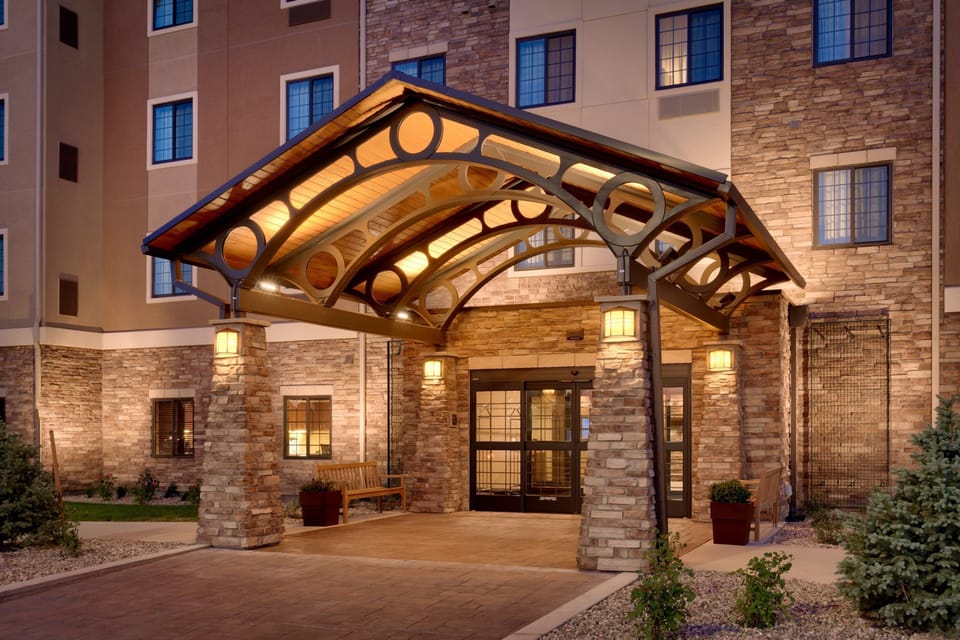 Hotel exterior with covered entrance and stone facade.