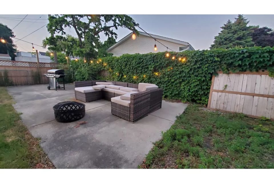 A nice sized yard has outdoor seating and firepit and an outdoor dining table.
