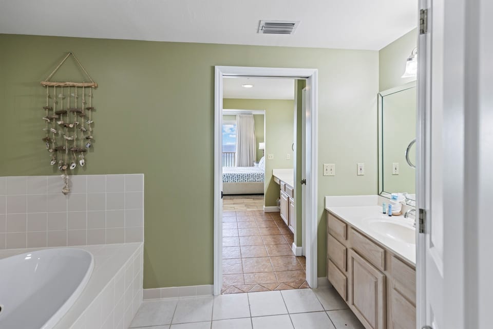 Relax in your spacious bathroom with soaking tub, dual vanities, and soothing coastal decor creating the perfect retreat.