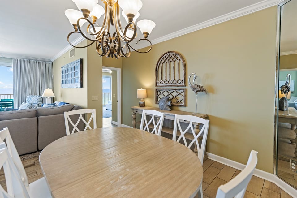 Your elegant dining space features coastal charm with a round table for memorable meals and glimpses of blue through the windows.