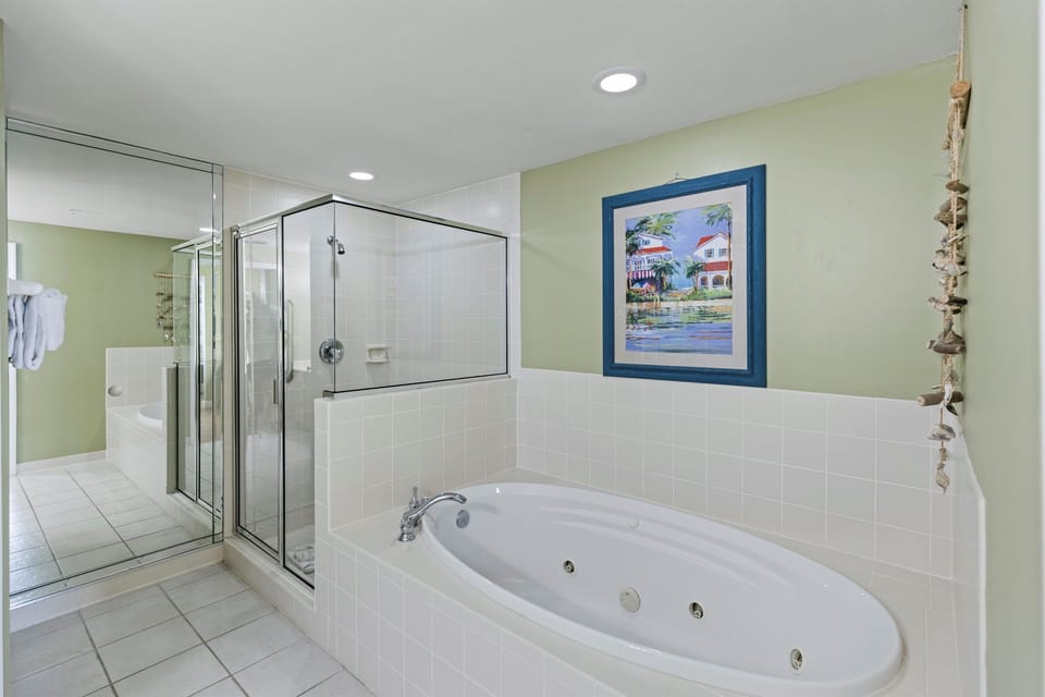 Unwind in your spacious bathroom featuring a luxurious jetted tub and separate glass shower—your perfect retreat after island adventures.