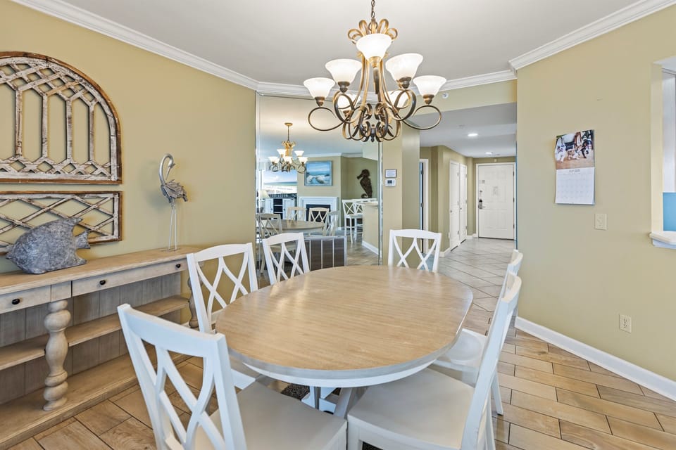 Gather around this elegant dining table where memorable meals and conversations await, beautifully illuminated by the graceful chandelier above.