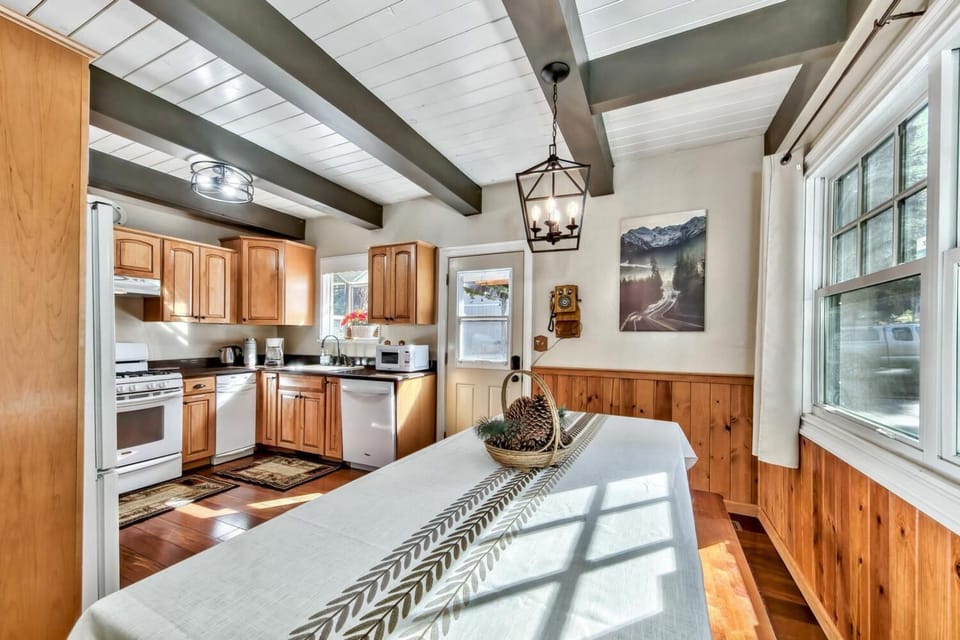 Gather around the rustic dining table where warm wood beams and natural light create the perfect spot for your morning coffee or evening meals.