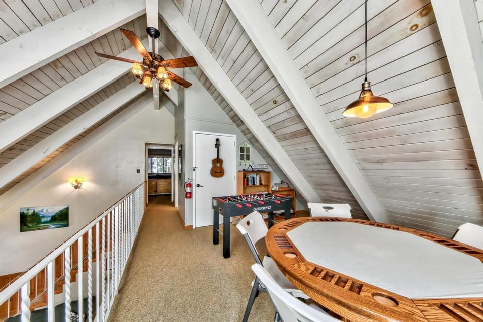 Your private loft game room features a foosball table and card table under rustic beams, perfect for cozy evenings of friendly competition.