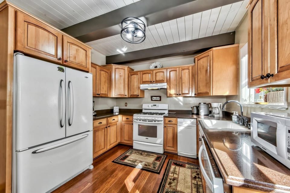 Your spacious kitchen features warm wood cabinets, granite countertops, and full appliances for preparing memorable meals together.