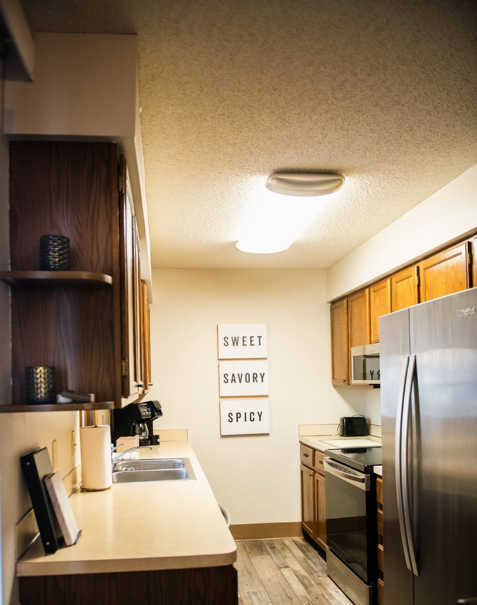 Cute little galley kitchen with new stainless steel appliances.  
