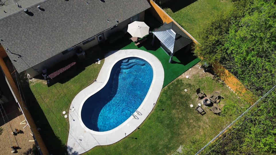 Aerial view of the private backyard featuring a pool, gazebo, hot tub, and outdoor seating areas.
