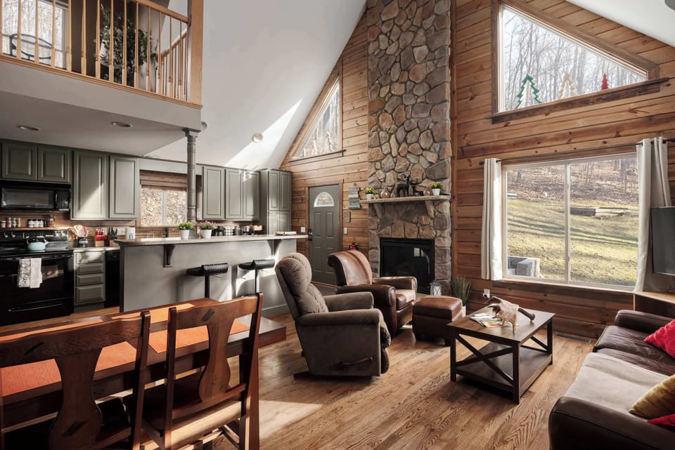  Spacious Open-Concept Living – A bright, open living space with vaulted ceilings, a stone fireplace, and a fully equipped kitchen.