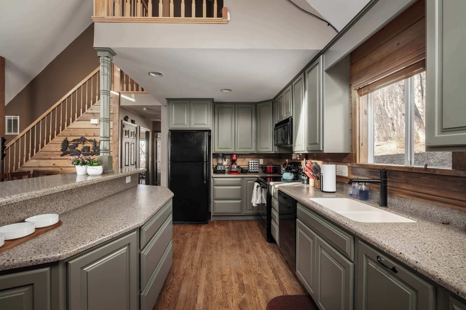 Expansive Kitchen & Bar Area – Prepare meals with ease in this spacious kitchen featuring a breakfast bar and rustic cabinetry.