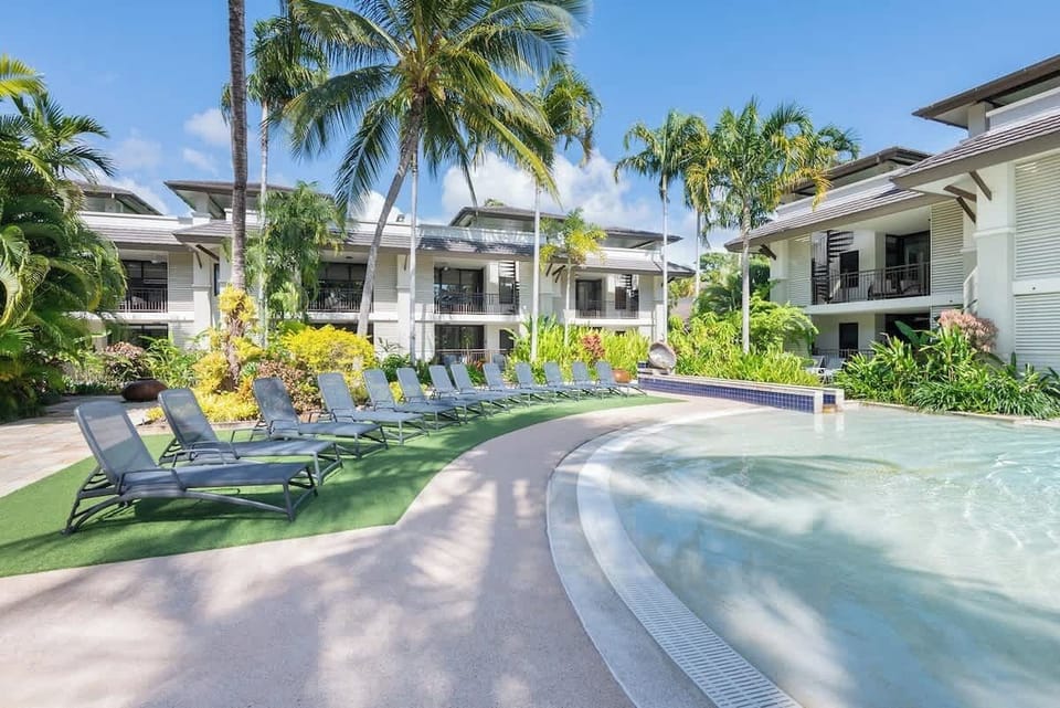 Dive into tropical vibes and endless relaxation by the shimmering pool, surrounded by lush greenery.