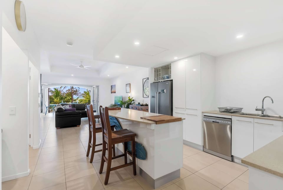 The kitchen highlights premium appliances and centres around an oversized island with seating to enjoy a quick bite to eat before hitting the beach.