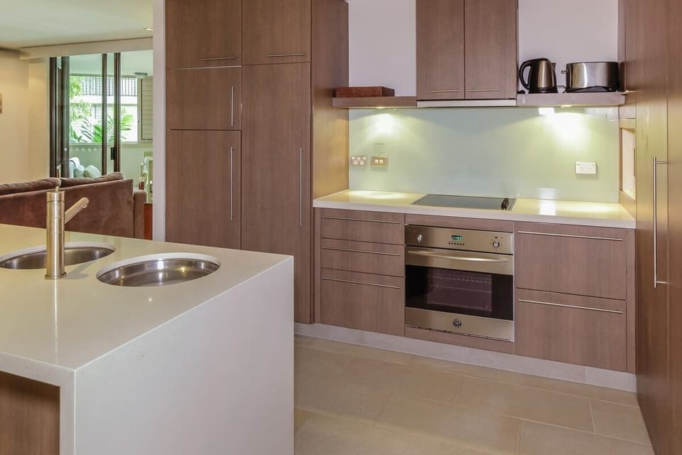 Cook with ease in the fully equipped kitchen, featuring sleek cabinetry and modern appliances.